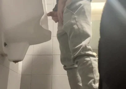 2 Boys in Sneakers Having Fun at Public Toilets' Urinal