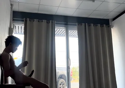 A Handsome Young Man Jerks off in Front of a Glass Door