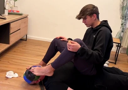 German master sitting on feet licking boy